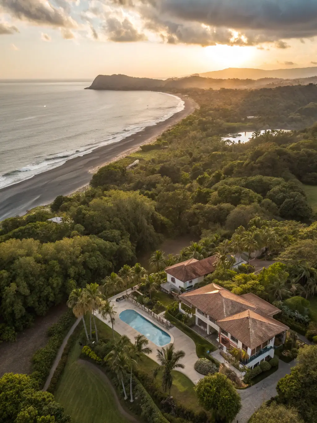 A drone shot capturing a stunning aerial view of a luxury real estate property in Jacó, Costa Rica, showcasing its prime location and upscale features.